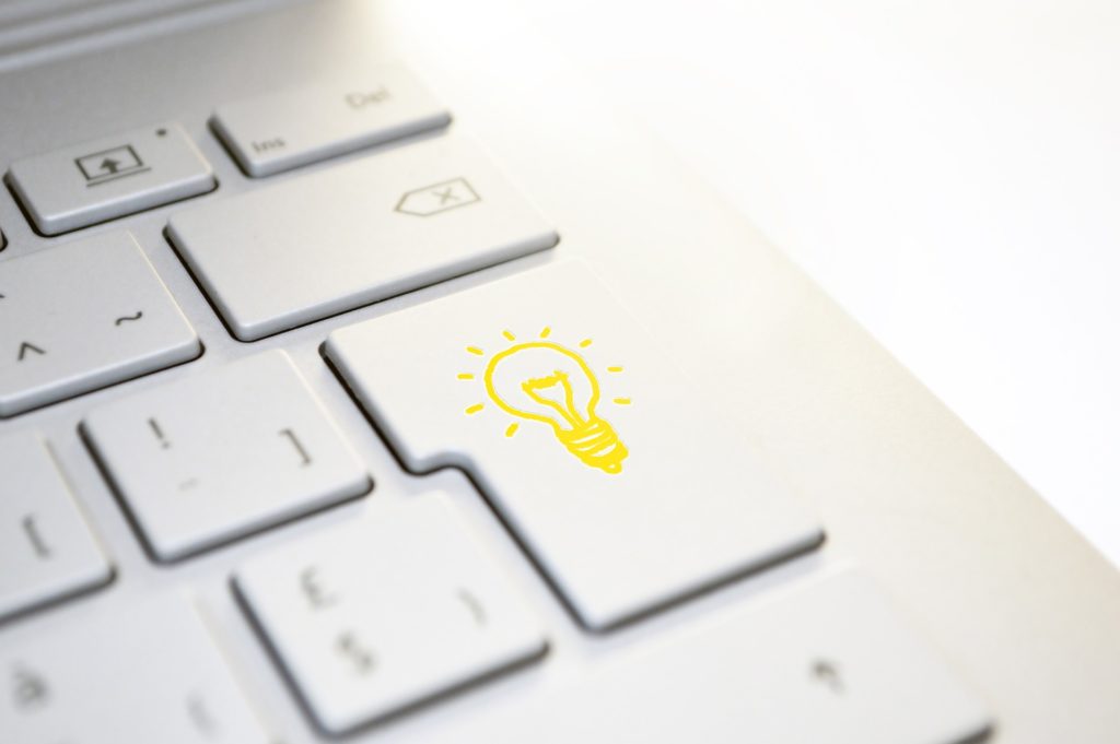 Zu sehen ist eine weiße Tastatur und auf der Enter-taste ist eine gelbe Glühbirne abgebildet.