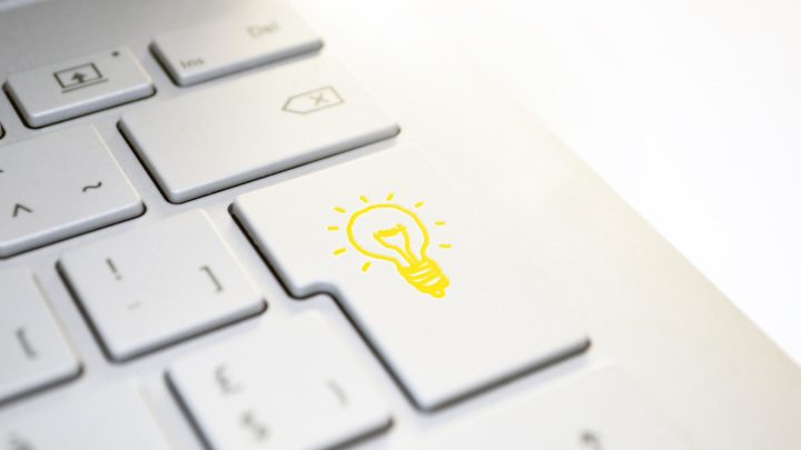 Zu sehen ist eine weiße Tastatur und auf der Enter-taste ist eine gelbe Glühbirne abgebildet.