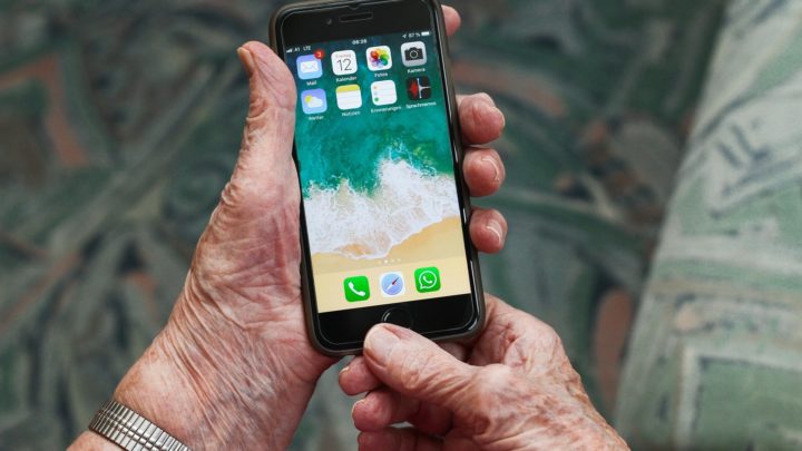 Seniorin hält ein Smartphone in der Hand