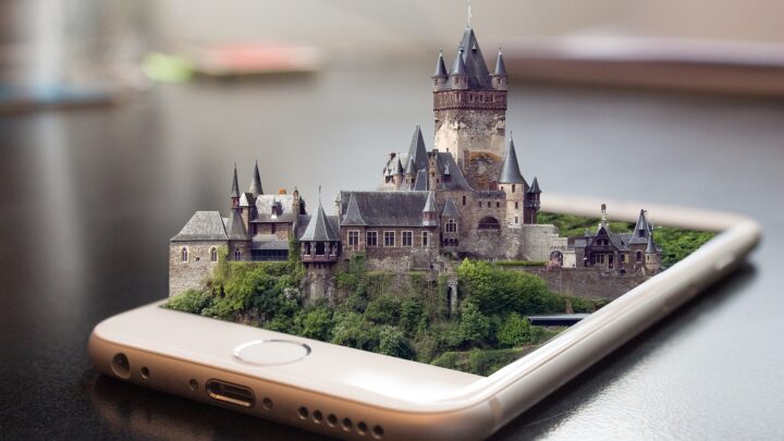 Zu sehen ist ein liegendes Smartphone auf dem über eine 3D Animation eine Burg liegt.